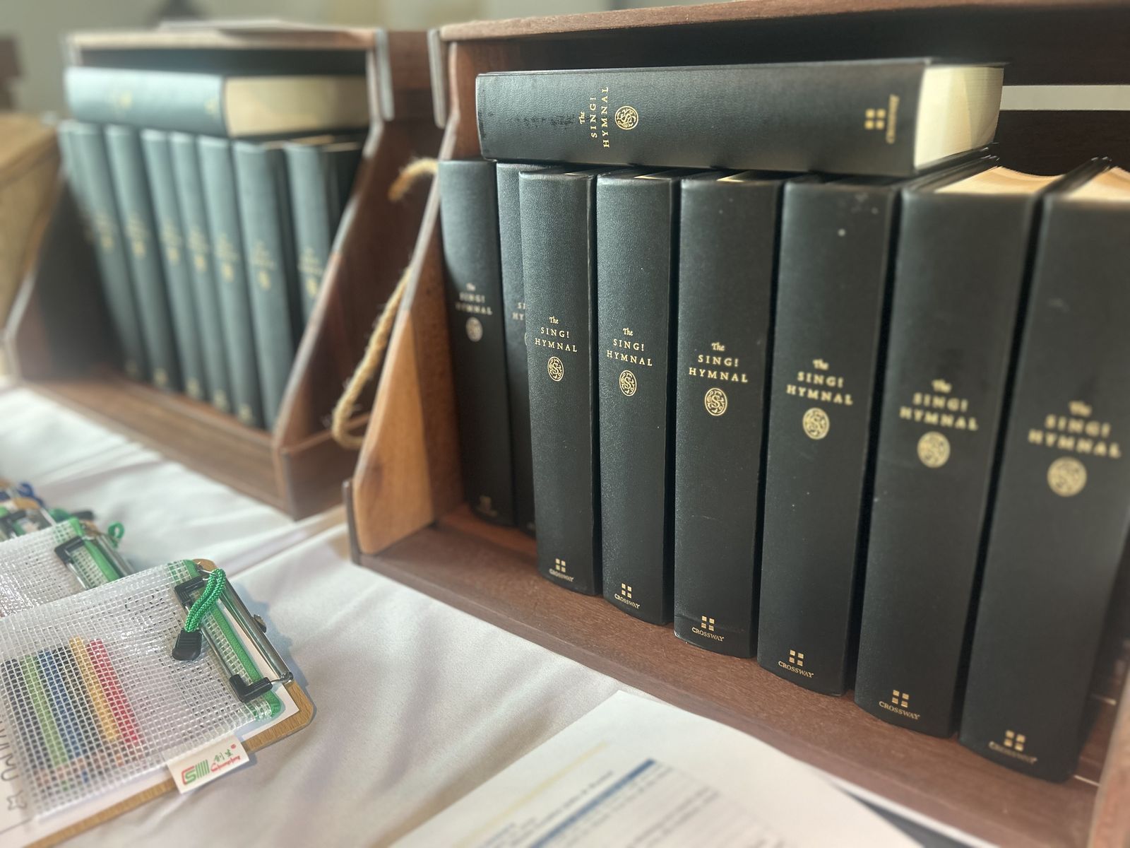 Copies of the Sing! Hymnal on a shelf